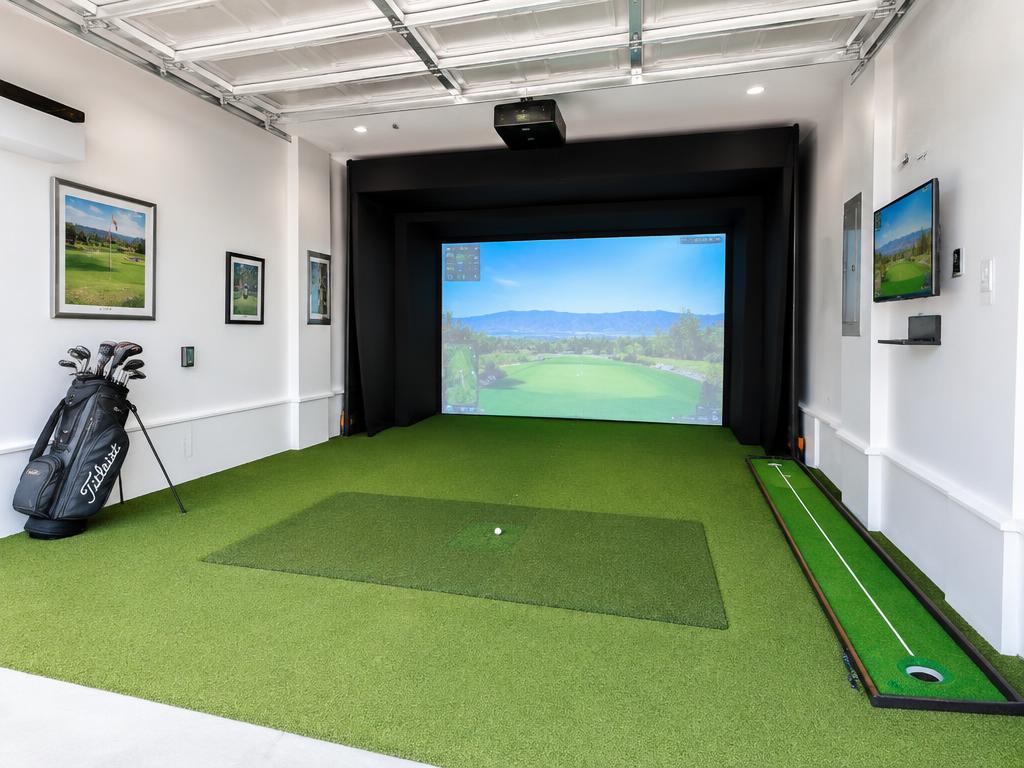 Converted garage golf simulator bay with putting strip